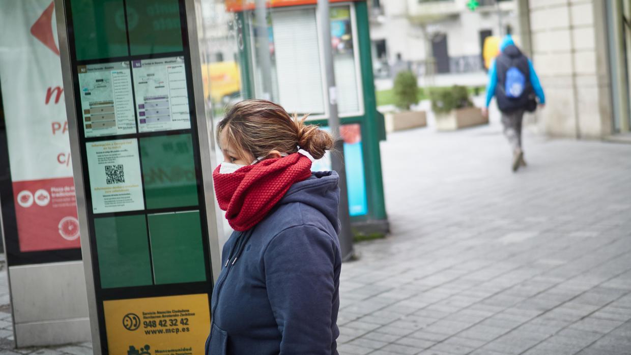 Una mujer se protege del coronavirus con una mascarilla