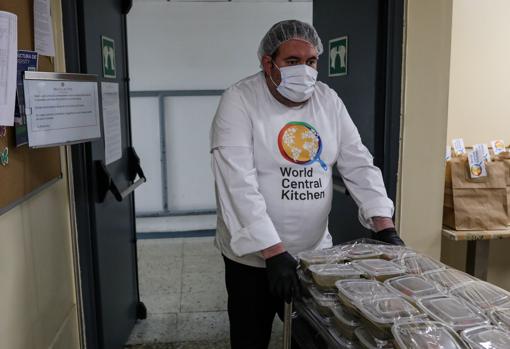 Un trabajador voluntario del restaurante El Qüenco de Pepa prepara en paquetes menús solidarios en colaboración con la ONG de José Andrés, Central World Kitchen