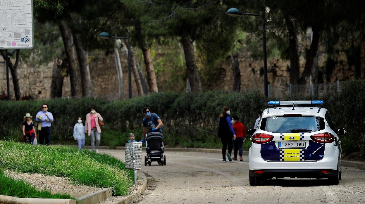 Un coche de la Policía Local de Valencia circula por el jardín del río Turia en el cuadragésimo tercer día del estado de alarma