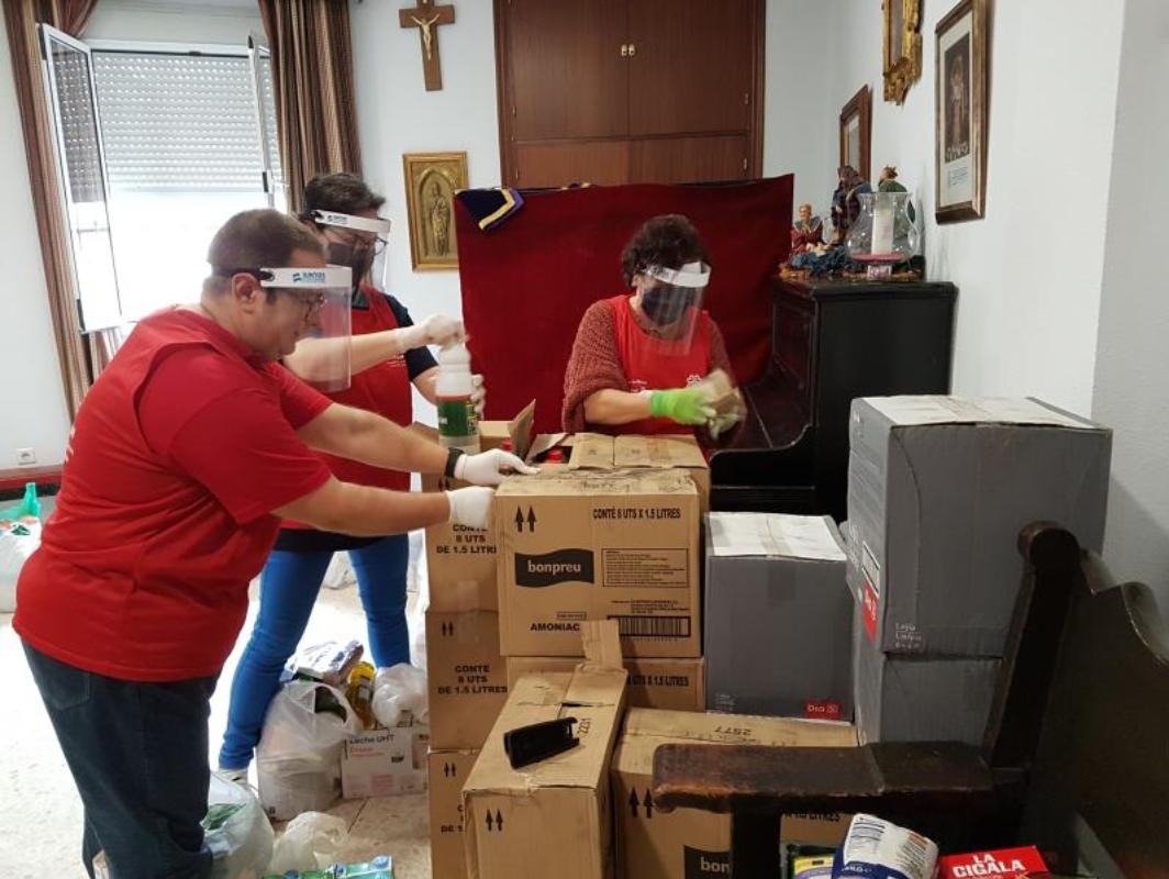 Voluntarios de Cáritas organizan los productos destinados a la ayuda por los afectados por la crisis del coronavirus