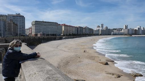 Una mujer en el paseo marítimo de La Coruña (Galicia)