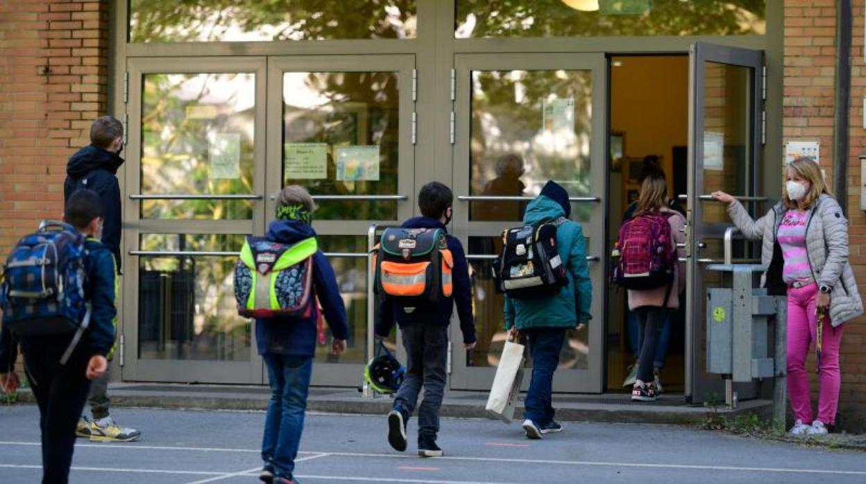 Los niños respetan las reglas de distanciamiento social al entrar en una escuela primaria en Dortmund, Alemania