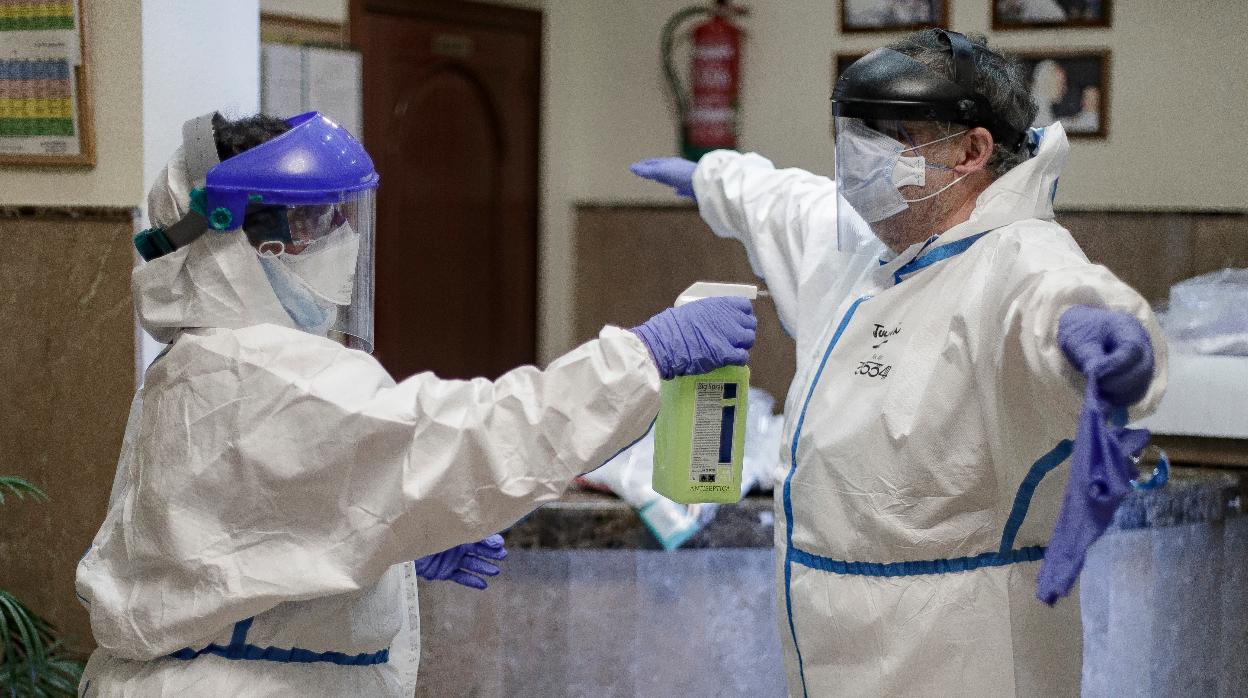 Una trabajadora desinfecta al doctor del centro en el interior de la Residencia de Mayores Jesús del Buen Amor