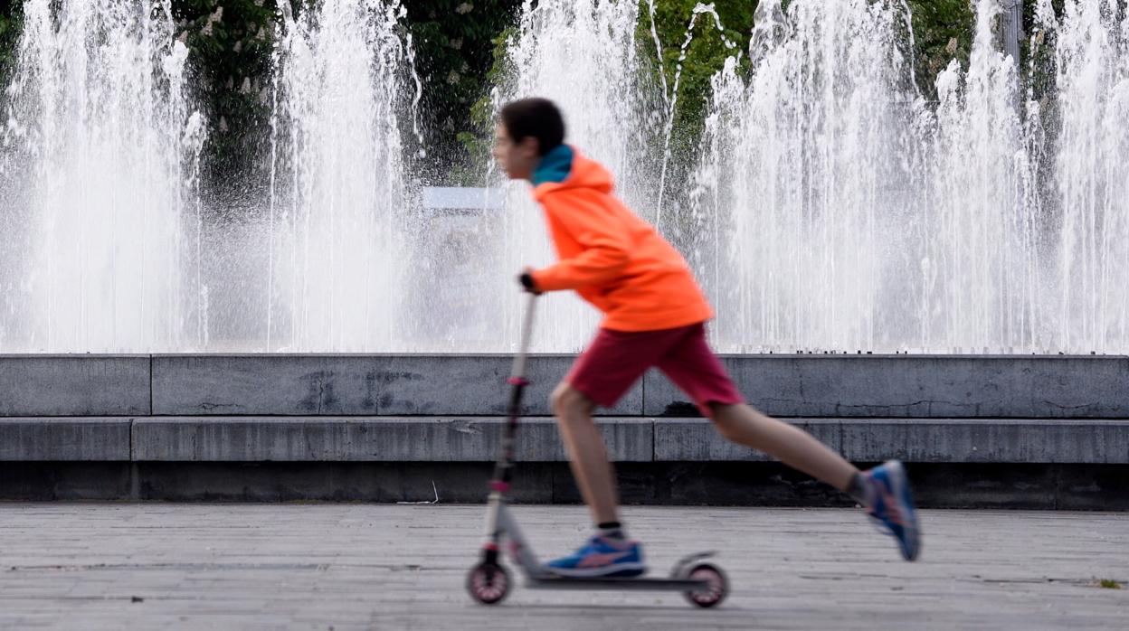 Un niño pasea con su patinete