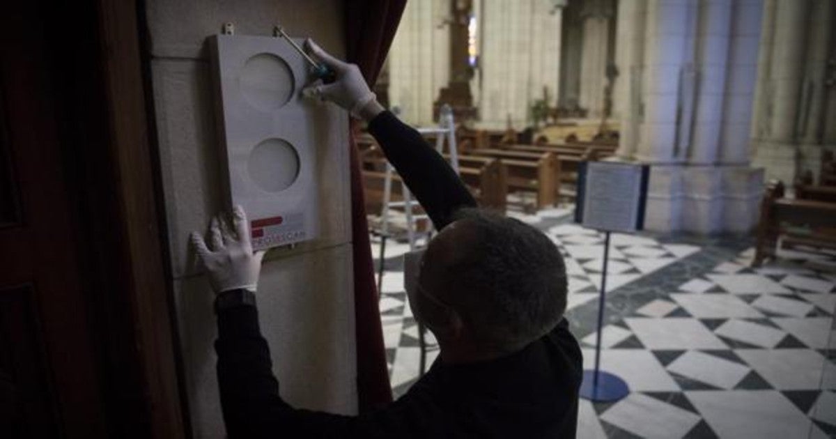 Un operario instala un semáforo en la catedral de La Almudena (Madrid) para controlar el aforo