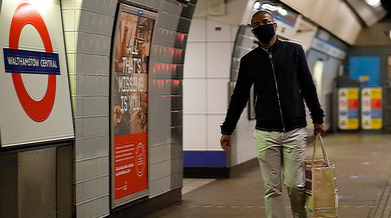 Un hombre con mascarilla en una estación del metro de Londres