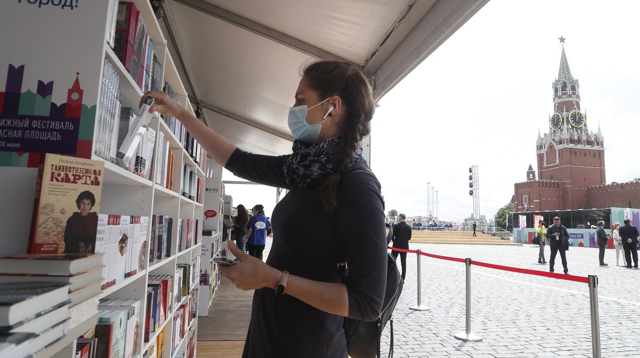 Una joven con mascarilla en una feria del libro celebrada estos días en Moscú