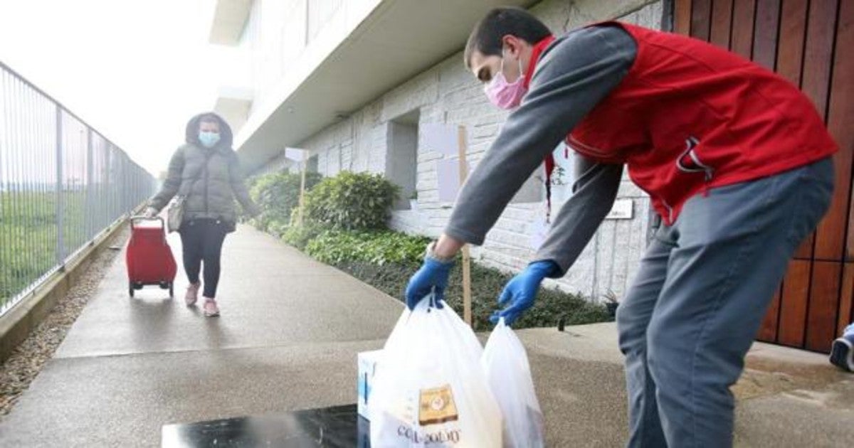 Voluntarios de la Cruz Roja reparten comida en las parroquias