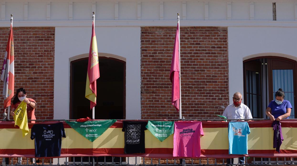 Varios concejales colocan camisetas de las peñas en el balcón del ayuntamiento de Viana de Cega (Valladolid)