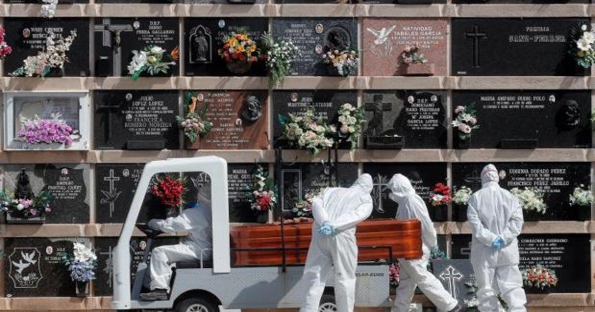 Personal del cementerio del Cabañal (Valencia) transporta un féretro durante un entierro