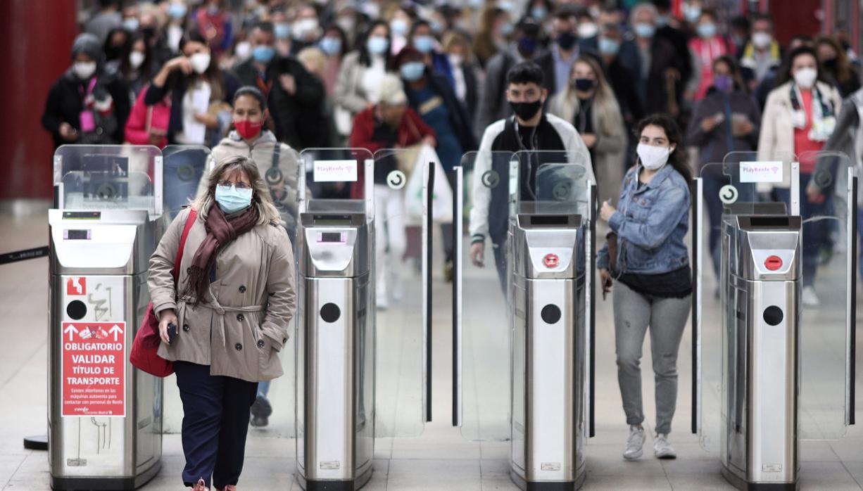 Usuarios del metro caminan, portando la mascarilla, por las instalaciones del metro