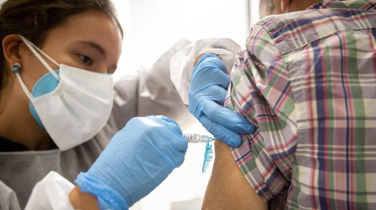 Un sanitario administra una vacuna