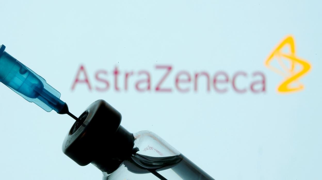 Fotografía de archivo de una jeringuilla y un vial en primer plano y el logo de AstraZeneca al fonfo