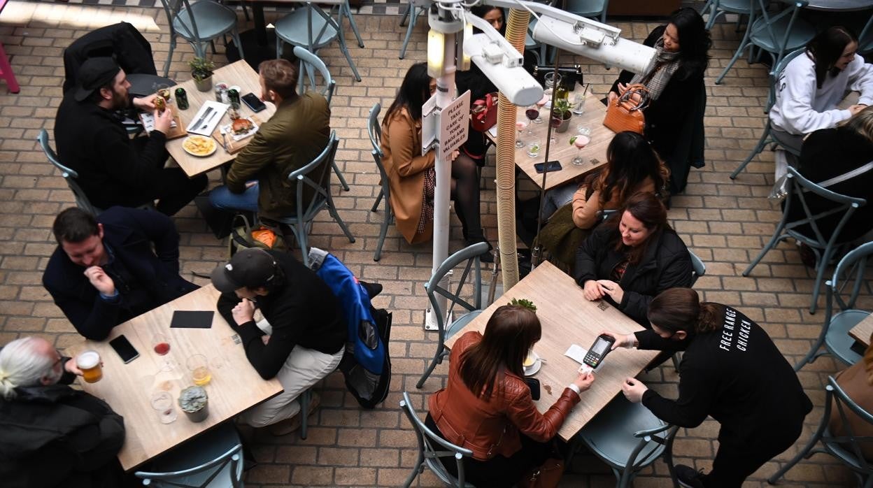 Varios clientes almuerzan en la terraza de un bar en la reapertura de Londres