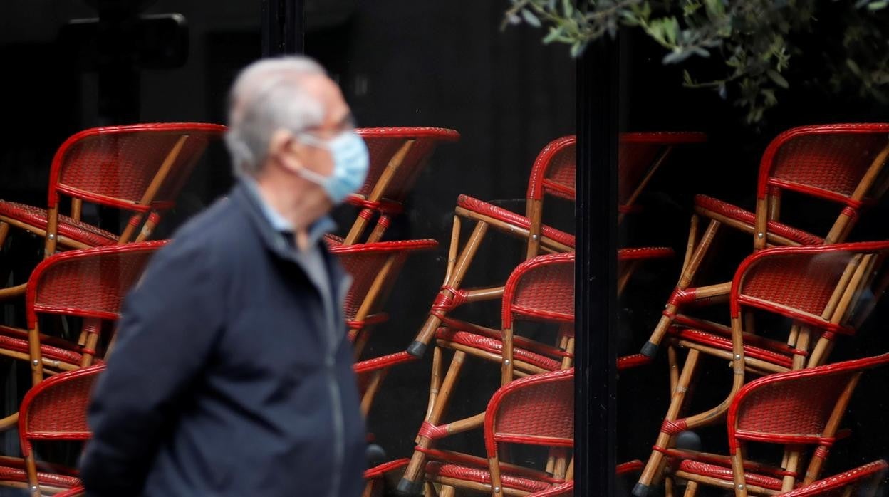 Un hombre con mascarilla pasea por las calles de París