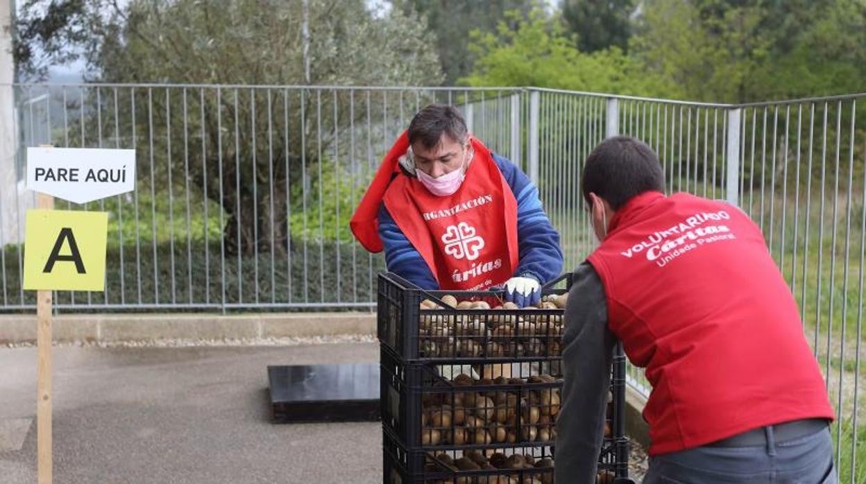 Un par de voluntarios de Cáritas llevan alimentos a un comedor social