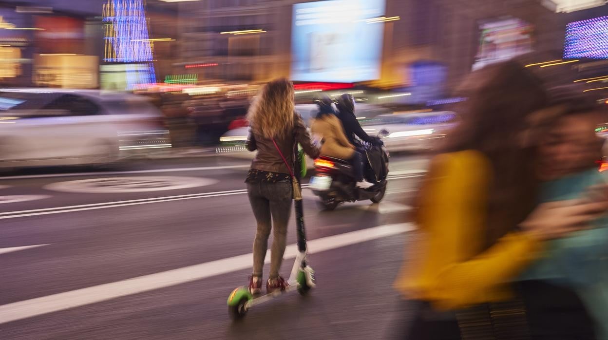 Una joven circula en patinete eléctrico por Madrid