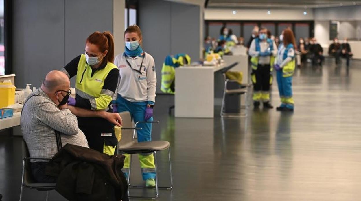 Una sanitaria vacuna a un hombre en el estadio Wanda Metropolitano en Madrid