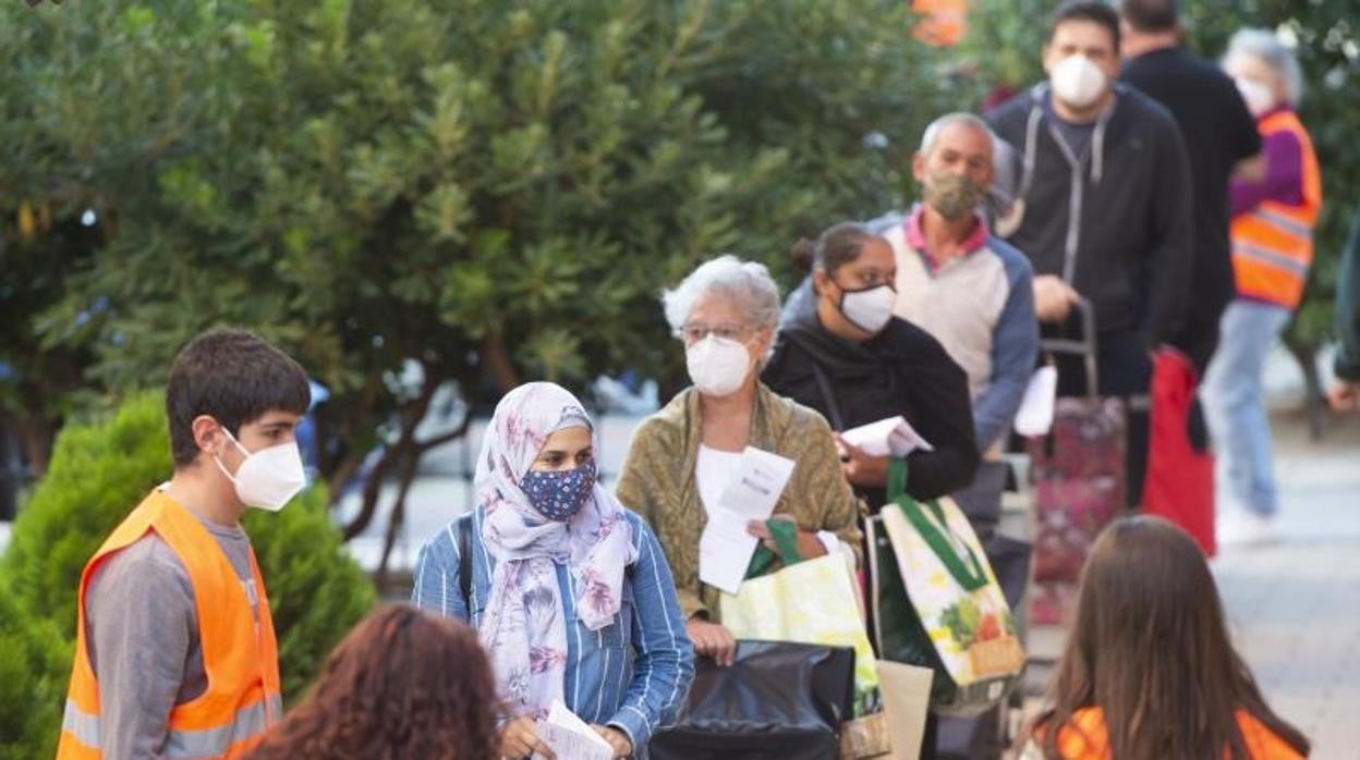 Cola de gente que recoge comida a través de Cáritas en la parroquia San Juan de Dios, en Vallecas