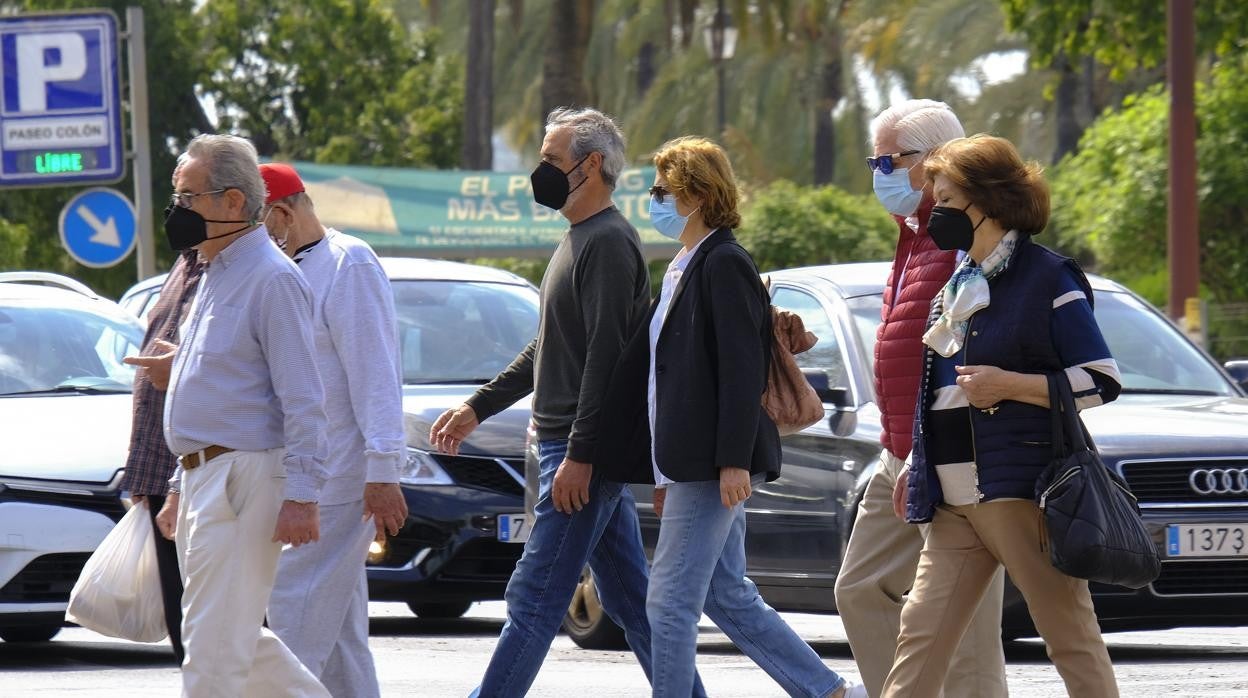 Personas caminan por la calle con mascarilla