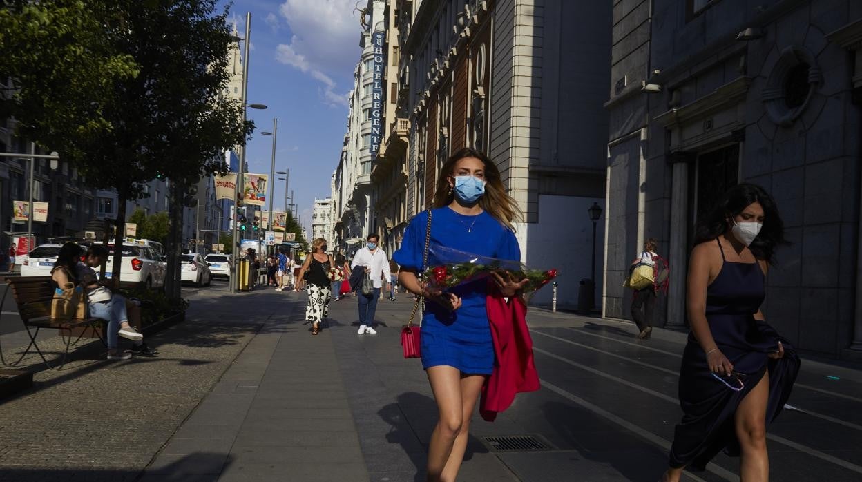 Gente paseando con mascarilla en la Gran Vía de Madrid