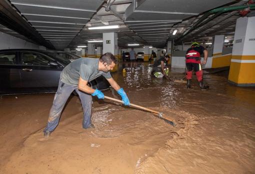 Trabajadores del Ayuntamiento de Águilas achican agua del garaje de un hotel, tras la gota fría de este jueves