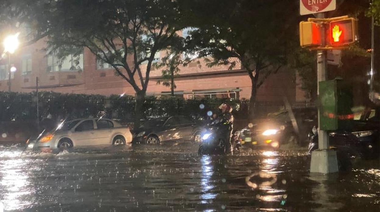 Un hombre en una moto atraviesa la inundación en el distrito de Queens de Nueva York