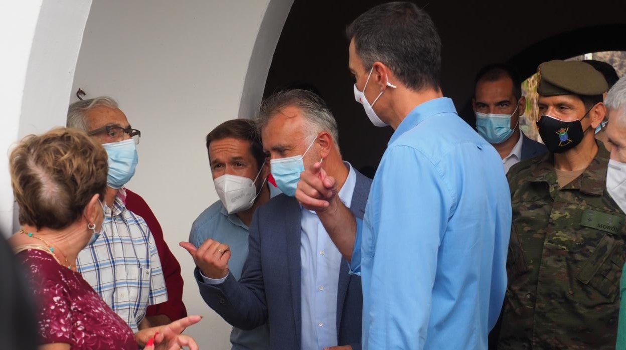 El presidente de Canarias, Ángel Víctor Torres, y el presidente del Gobierno, Pedro Sánchez, conversan con una vecina durante su visita al Centro de acogida de afectados por la emergencia volcánica, ubicado en el acuartelamiento de El Fuerte