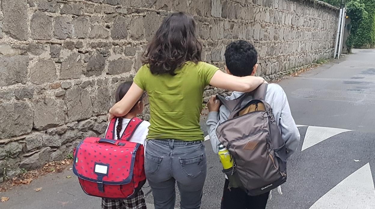 S. G. junto a sus dos hijos de camino a la escuela