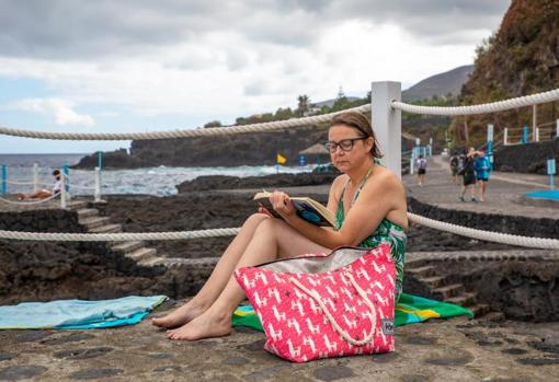 Susanne, una turista de Suecia pero residente en Londres lee en las piscinas naturales de San Andres y Sauces
