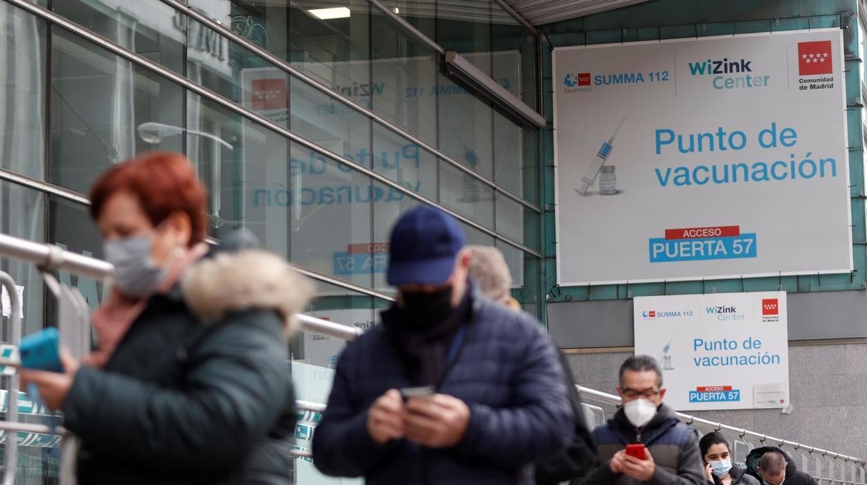 Varias personas hacen cola en el WiZink Center para vacunarse contra el Covid-19