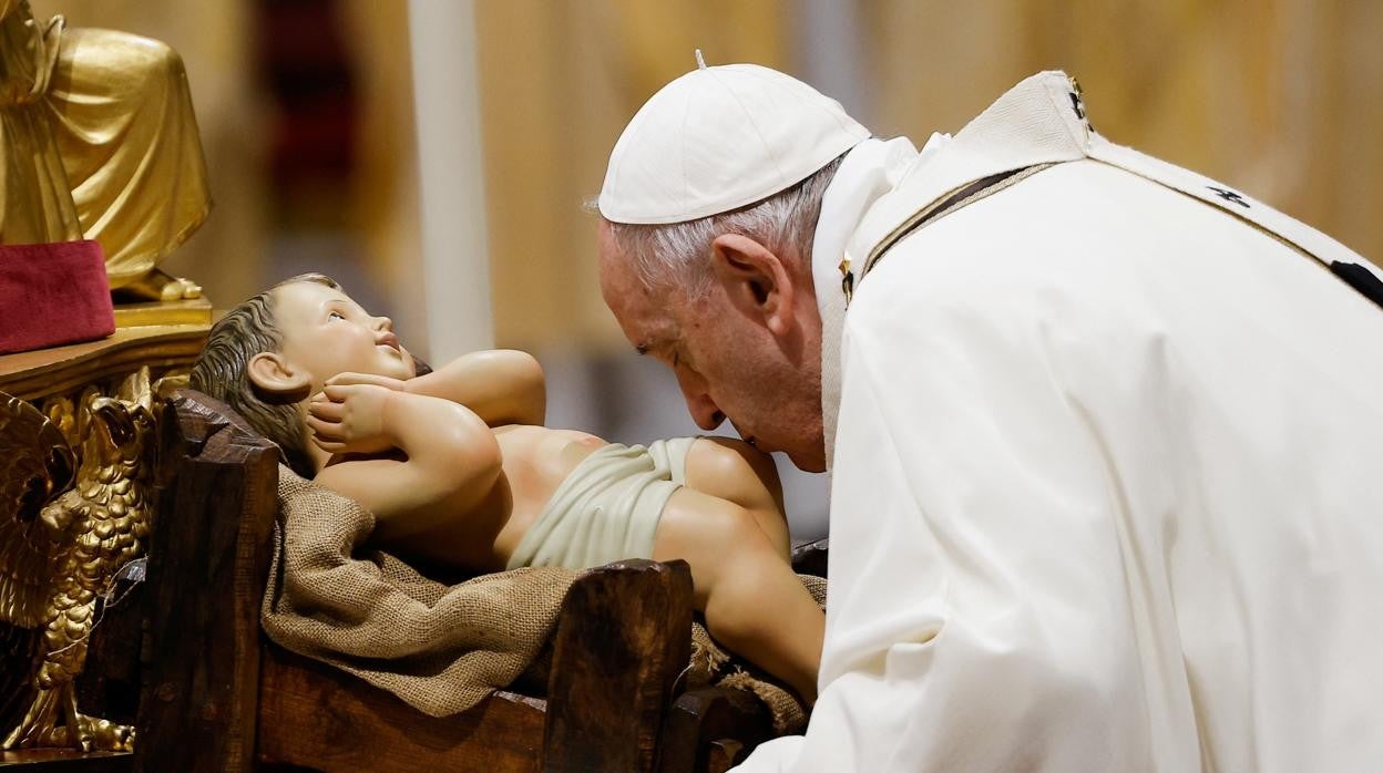 El Papa Francisco besa una imagen del Niño Jesús en el Vaticano durante la misa de Nochebuena