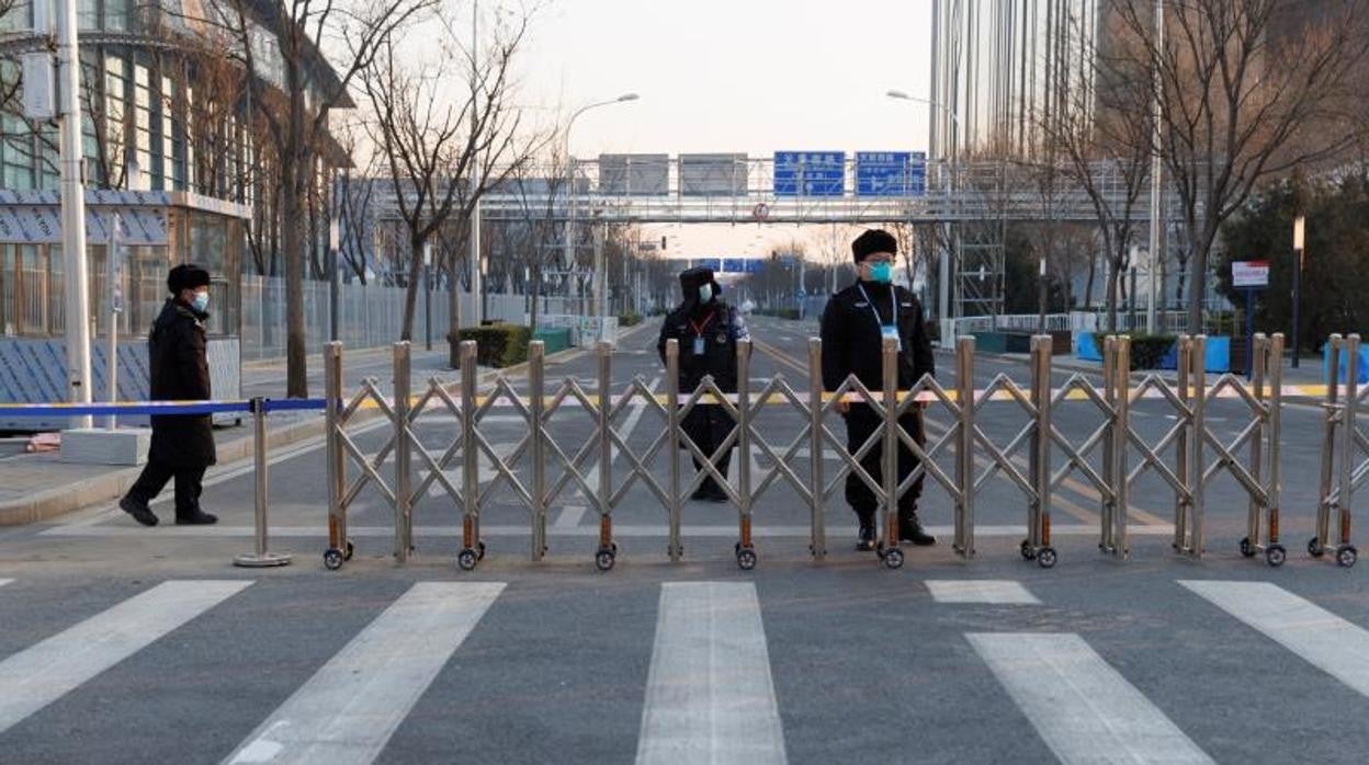 Los guardias vigilan una puerta a un área de circuito cerrado diseñada para prevenir la propagación del coronavirus cerca de las sedes de los Juegos Olímpicos de Invierno de Beijing 2022