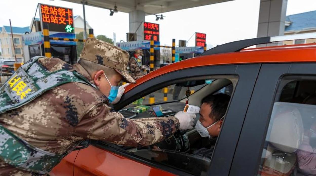 Un militar toma la temperatura a un conductor en Wuhan (China)