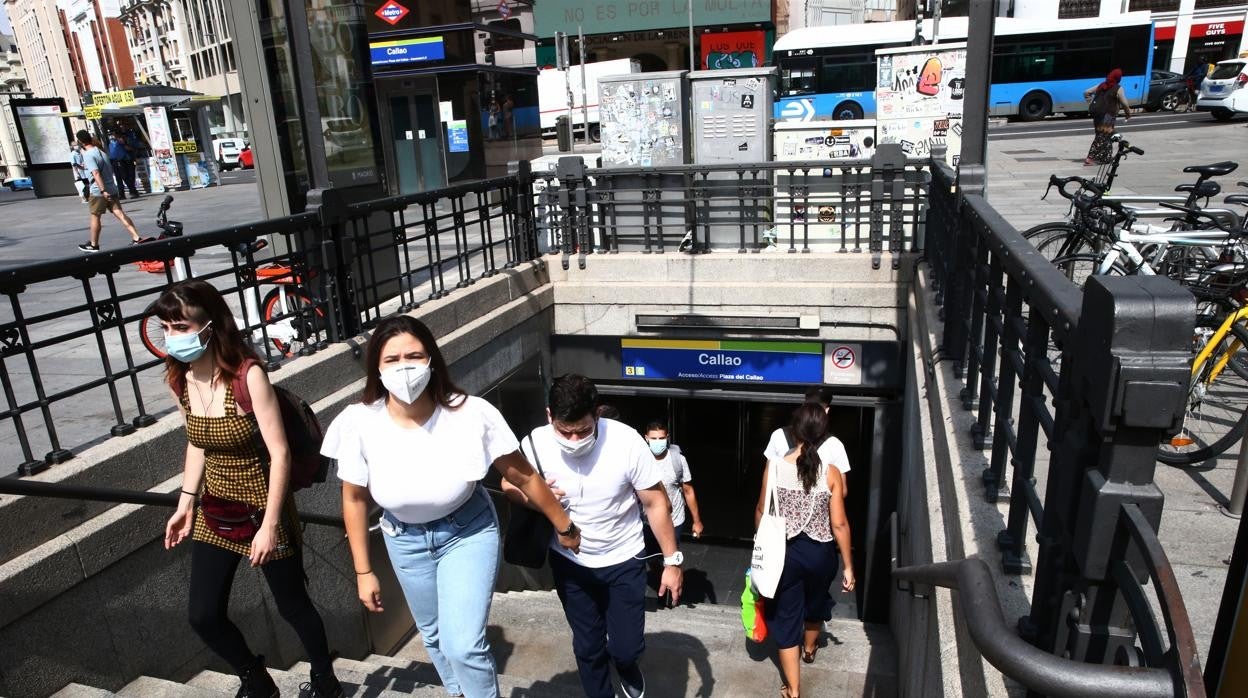 Personas entrando y saliendo de la boca de metro de Callao en Madrid