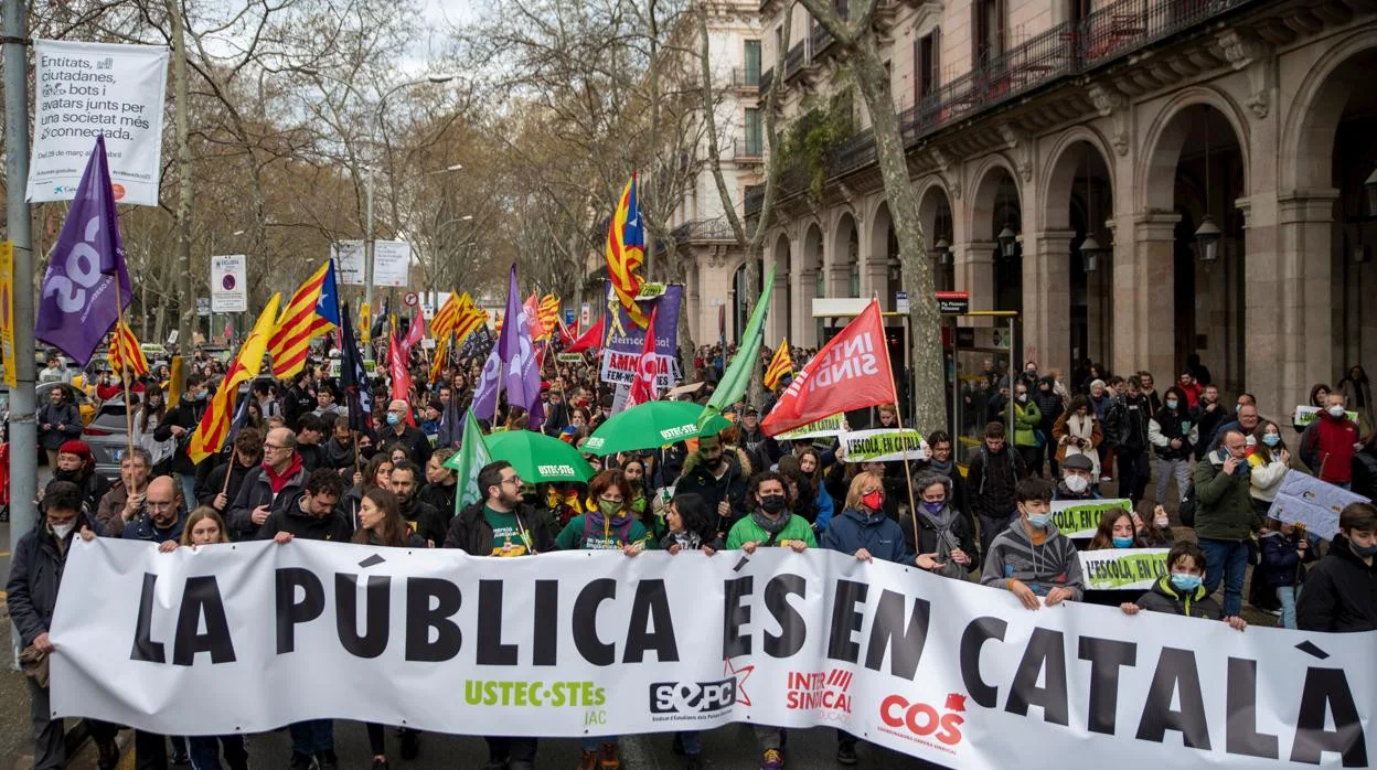 Varios manifestantes con pancartas que rezan 'La pública es en català', en una huelga por la sentencia del 25% en castellano en la educación catalana, a 23 de marzo de 2022, en Barcelona