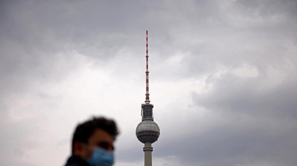 Un hombre con mascarilla camina en la plaza de Alexanderplatz, en Berlín