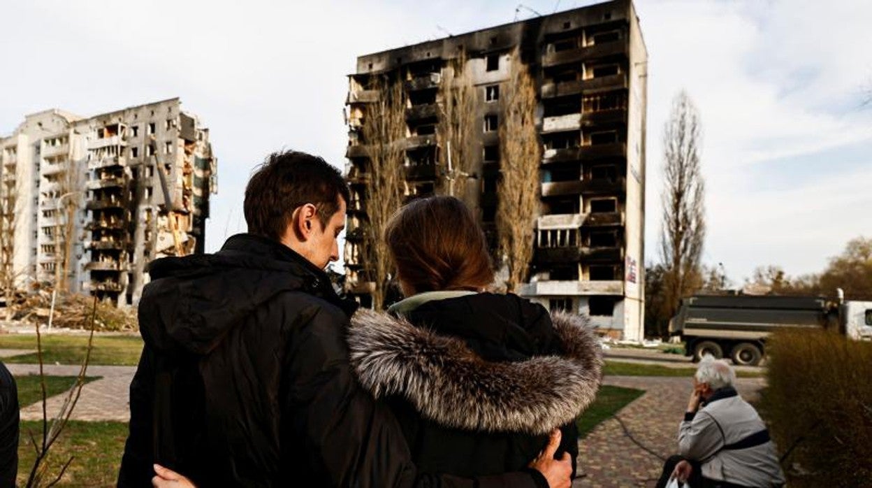 Una pareja contempla su edificio destruido por las tropas rusas en Kiev