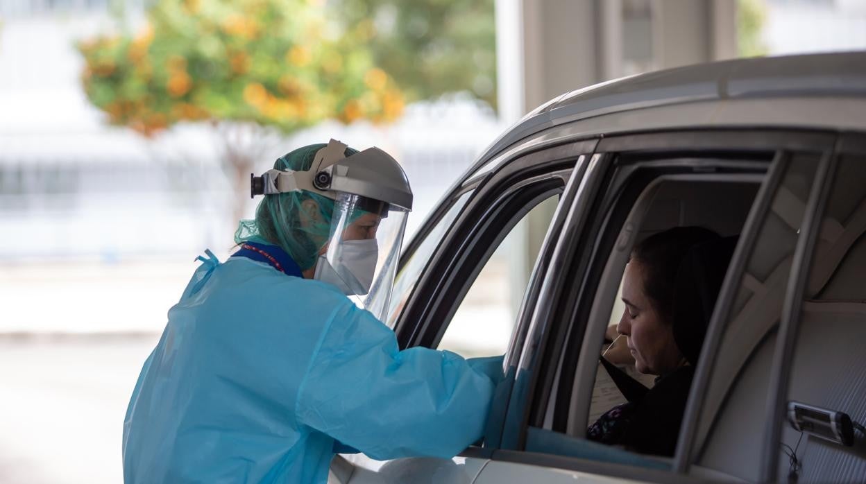 Imagen de archivo de una enfermera realizando una PCR a una mujer desde un coche