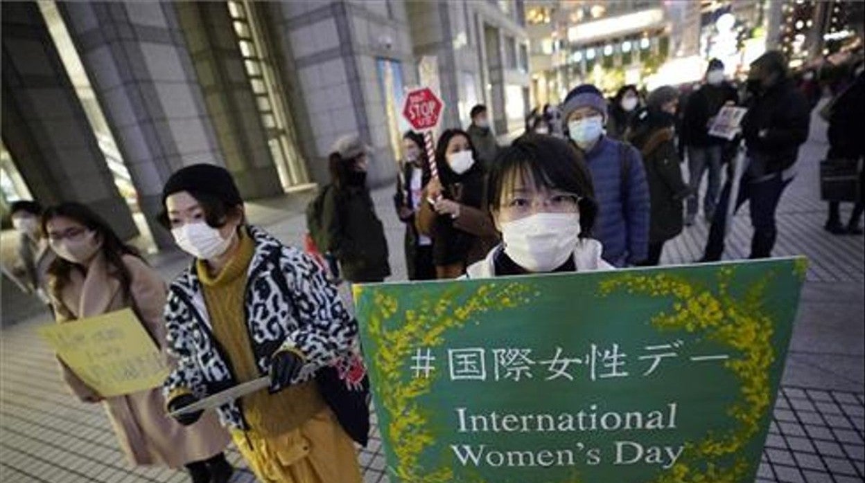 Una joven sostiene una pancarta mientras participa en una manifestación contra la violencia de género y la discriminación en Tokio