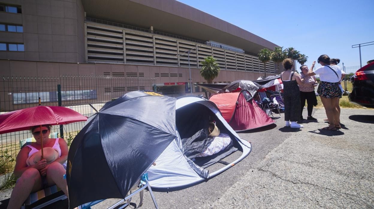 Una veintena de personas, en plena ola de calor, hacen ya cola para el concierto, del próximo sábado, del artista onubense Manuel Carrasco en el Estadio de la Cartuja, en Sevilla