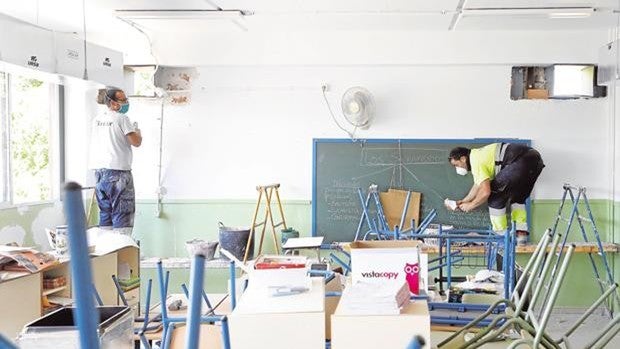 Operarios instalan aparatos de aire acondicionado en un colegio de Córdoba