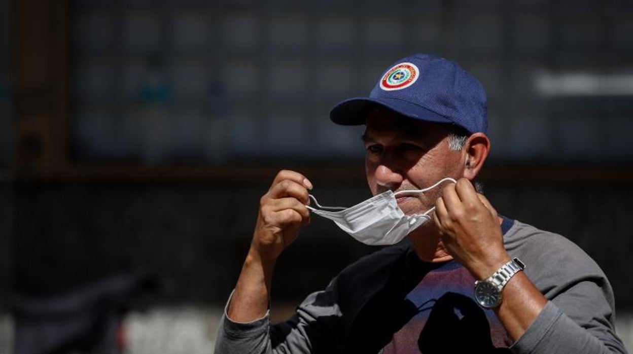 Un hombre se quita la mascarilla al aire libre