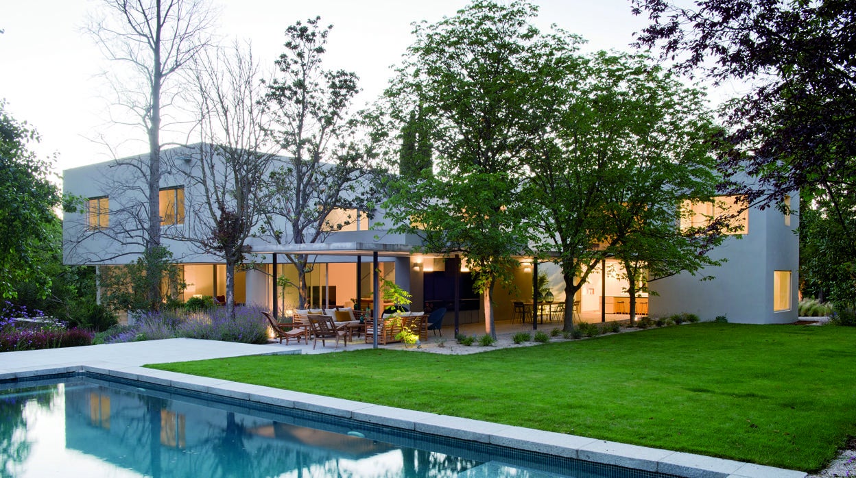Exterior y jardín con piscina de Casa L en Pozuelo y salón de Proyecto Ch en la Moraleja, ambos trabajos de Ábaton-Blanca Alonso.