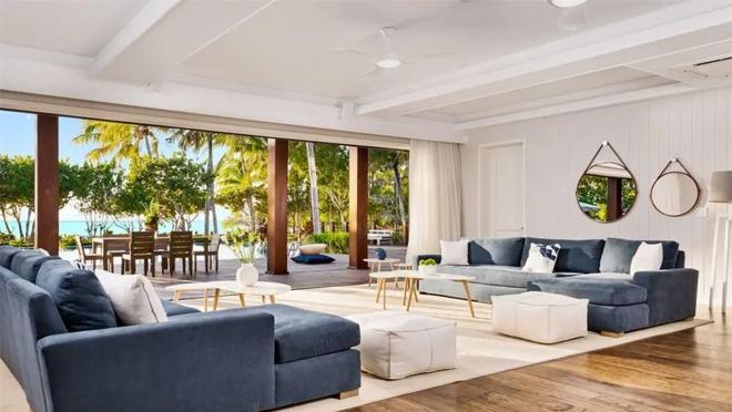 El salón comunica con el porche por un sistema de ventanales retráctiles de suelo a techo