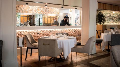 Sala con cocina vista en La Parrilla de la Máquina