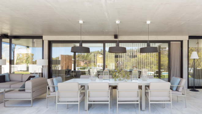 La zona exterior cuenta con un área de comedor techado con suelos de mármol