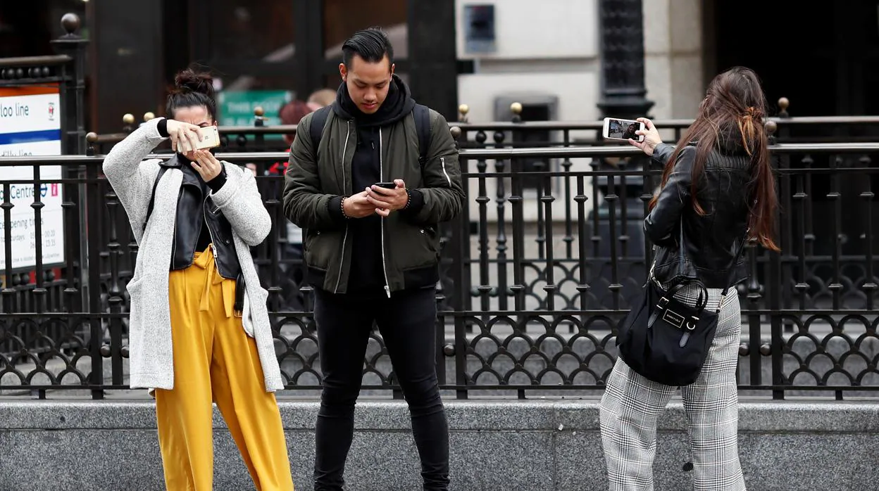 Jóvenes miran su teléfono móvil