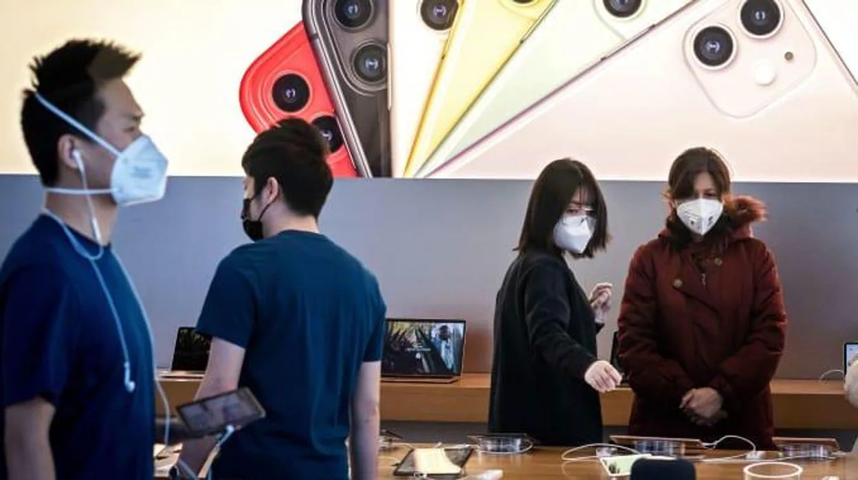Varias personas en China miran productos en una tienda de Apple