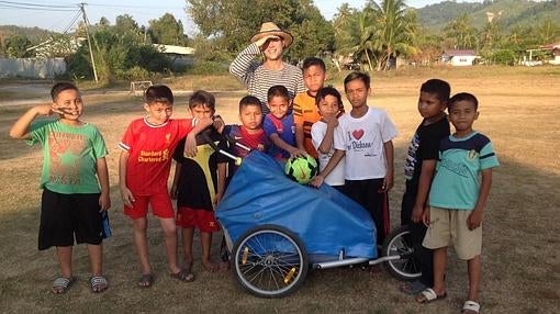 Nacho con un grupo de niños en el Archipiélago Langkawi (Malasia). Con ellos, Jimmy, el carro alemán para llevar bebés con el que ha recorrido el mundo